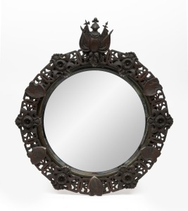 An antique circular mirror with ornate metal frame, adorned with armorial motif, 19th/20th century, ​​​​​​​46 x 40cm.