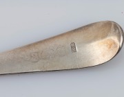 An antique sterling silver tablespoon and ladle with feather-edged decoration, 19th century, (2 items), 18cm and 21cm long, 98 grams total. - 2