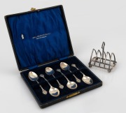 A boxed set of six sterling silver teaspoons, together with a sterling silver toast rack, 19th/20th century, the toast rack 7cm wide, 80 grams total.