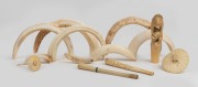 An attractive antique Japanese carved ivory parasol handle, two carved ivory cigarette holders, two carved ivory miniature parasols, and a group of assorted boar tusks, 19th/20th century, ​​​​​​​the handle 10cm high.