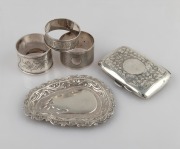 Antique sterling silver cigarette case, three sterling silver napkin rings, and an Indian silver dish, 19th/20th century, (5 items), 125 grams total.