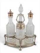 An antique sterling silver cruet stand with four cut crystal bottles, made in Birmingham, circa 1861, ​​​​​​​17.5cm high, the base and two silver caps, 309 grams total.