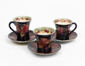 MOORCROFT "Pomegranate" set of three English pottery cups and saucers, (6 items), impressed factory mark and underglaze signatures to base, the saucers 10.5cm diameter.