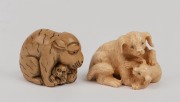 A carved mammoth ivory netsuke dog figure group; together with a carved ivory tiger and cub netsuke, the largest 4.5cm high.