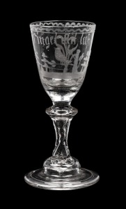 An antique Continental wine glass with wheel engraved decoration and hollow stem, early 19th century, 14cm high.