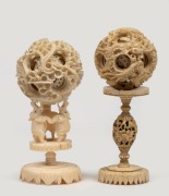 Two Chinese carved ivory puzzle balls on stands, 19th/20th century, 14cm and 15cm high overall.