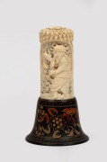 An Indian carved ivory ornament on hand-painted timber plinth, 20th century, 15cm high overall.