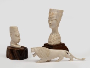 An Egyptian carved ivory pharaonic bust on timber stand; together with an African carved ivory lion and a bust on wooden stand, 20th century, (3 items), the largest 13cm high overall.