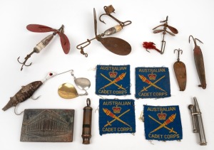 Vintage barramundi fishing lures, military whistle, assorted Australian Cadet Corps patches, trench art cigarette lighter and a bronze "Herald Sun" paperweight, (qty), the largest lure 20cm long overall.