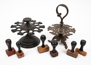 Two antique American cast iron desk top ink stamp holders with a selection of assorted hand stamps, 19th century, ​​​​​​​the larger 19cm high.