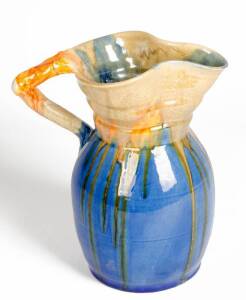 REMUED: Large pottery jug with branch handle & flared rim, glazed in blue, cream & orange. 25.5cm