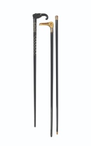Three antique walking sticks with ebony and ebonized shafts, two with animal head decoration, 19th/20th century, the largest 92.5cm high.