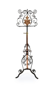 An antique French wrought iron, copper and brass adjustable music stand, designed with decorative scroll work, circa 1920, 125cm high.