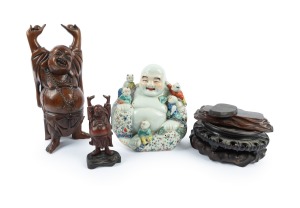 246 · A Chinese porcelain Buddha statue; together with two carved timber Buddha statues and four assorted timber stands, 20th century, (7 items), the largest 38cm high.