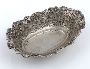 74 · An antique sterling silver bowl with floral repousse decoration 19th/20th century, 17cm wide, 99 grams.