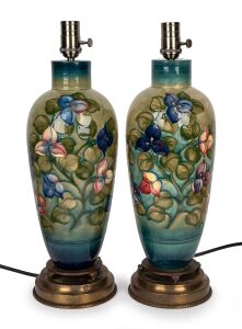 MOORCROFT "Bougainvillaea" pattern pair of porcelain table lamps on celadon green ground with brass bases and metal fittings, 50cm high overall.