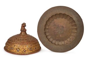 178 · A vintage Burmese serving tray with engraved floral border; together with a Burmese gilt lacquer ware cover with phoenix head handle, inlaid with glass decoration, 20th century, (2 items), 39cm high overall, the tray 59cm diameter.