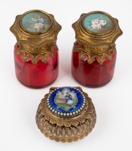 A pair of antique French ruby glass scent bottles with gilt metal mounts and hand-painted floral decoration, together with an antique French opaque glass trinket box with gilt metal mounts, enamel scene and seed pearl decoration, 19th century, (3 items), the bottles 6cm high