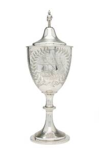 A stunning Australian silver trophy cup & cover "U.F.B.D (United Fire Brigades' Demonstration) SANDHURST 1883, Hose Practice....". Engraved with ferns & leaves with a detailed cartouche depicting fireman at work. Lid adorned with figural fireman finial. T