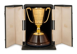 HOBART CUP, TASMANIAN RACING CLUB, 1952: Won by Royal Release. Fine quality two handled trophy cup in solid 9ct gold (237 grams), mounted on turned timber plinth and housed in original presentation case branded "Rundle's, Hobart", the cup 15cm high, 20cm high including plinth. Accompanied by an attractive framed photographic display of the horse and jockey with owner's details in manuscript lower right "Mr C. E. Pritchard and Miss G. Pritchard, Trainer A. Hunt, Rider R. Hutchinson".