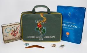 1956 MELBOURNE OLYMPICS: Seat cushion from the opening ceremony, chocolate tin, boomerang ornament and badge; together with SYDNEY 2000 badges and medallions, (qty).