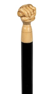 An antique walking stick with carved marine ivory snake and fist hand grip, ebony shaft and brass ferrule, 19th century, 83cm high.