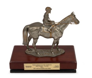 BLUE DIAMOND STAKES: 2003 winner's trophy for Kusi, Royal Selangor pewter statuette by sculptor R. Cameron, on timber plinth with plaque that reads "Thoroughbred Club of Australia, John Hawkes - Trainer, Kusi, 2003 AAMI Blue Diamond Stakes Winner, Melbourne Racing Club, Caulfield Classic", height 19cm; together with a "AAMI Blue Diamond Stakes - 4 - KUSI" strapper's bib. (2 items)