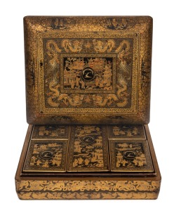 An antique Chinese export ware lacquered box with gilt decorated finish, bearing family crest with the motto "IN VERO RIGHT", interior handsomely fitted with five lidded compartments also beautifully decorated in the chinoiserie style and bearing the same family crest, mid 19th century, 10cm high, 30cm wide, 26cm deep.