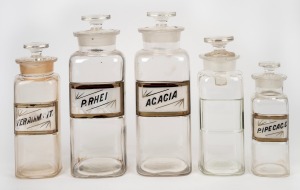 Group of five assorted antique glass apothecary jars, four of which with original labels "Acacia", "P. Rhei", "Feramm. Cit.", and "P. Ipecac. C.", all lids present, late 19th/early 20th century; the tallest 25cm overall. (5 items)