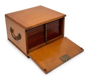 An antique coin collector's cabinet, crafted in oak with fall front revealing a bank of twelve coin slide storage drawers, 19th/20th century, 17cm high, 28m wide, 28cm deep.
