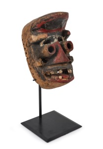 A tribal Dan Gere mask, carved wood with painted finish on bespoke stand, Liberian origin, the mask 26cm high, 46cm high overall.