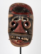 A tribal Dan Gere mask, carved wood with painted finish on bespoke stand, Liberian origin, the mask 26cm high, 46cm high overall. - 2