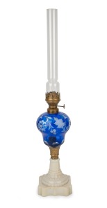 An antique oil lamp with blue overlay glass font, milk glass base, single burner and original chimney, 19th century, 55cm high overall.