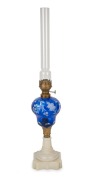 An antique oil lamp with blue overlay glass font, milk glass base, single burner and original chimney, 19th century, 55cm high overall.