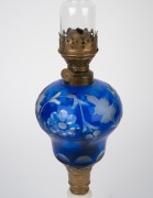 An antique oil lamp with blue overlay glass font, milk glass base, single burner and original chimney, 19th century, 55cm high overall. - 2