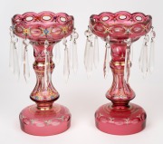 A pair of Bohemian overlay ruby glass lustres with hand-painted floral enamel decoration, 20th century, 25cm high.