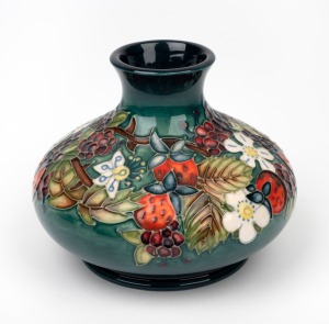 MOORCROFT floral pattern English pottery vase on green ground, circa 1990, limited edition signed by John Moorcroft, 10.5cm high, 13cm wide.