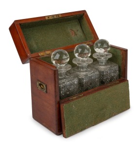 An antique mahogany cased campaign tantalus, housing three hobnail cut crystal decanters, 19th century, 26cm high, 30cm wide, 13cm deep.