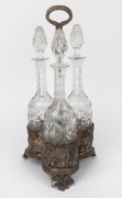 An antique silver plated decanter stand with three crystal decanters, 19th century, 46cm high.