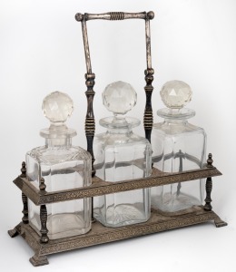 An antique silver plated tantalus with swing handle, housing three assorted decanters, 19th/20th century, 36cm high handle up.
