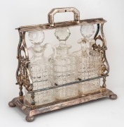 An antique silver plated tantalus, housing three decanters, 19th/20th century, 33cm high.