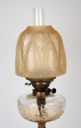 An antique banquet lamp with clear cut crystal font, black button double burner, acid etched peach shade and brass column bird cage base, 19th century, 77cm high overall. - 2