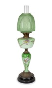 An antique banquet lamp with hand-painted green glass font and column in the Art Nouveau style with double burner, acid etched shade and chimney, 19th/20th century, 75cm high.