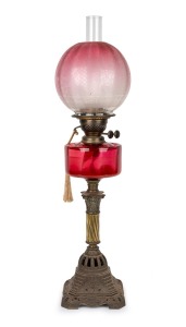 An antique oil lamp with faceted ruby glass font, double burner, acid etched shade and Corinthian column and gilt metal base, 19th/20th century, 74cm high.