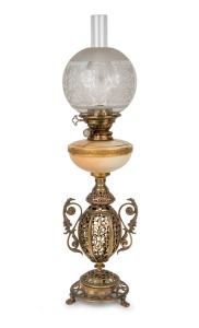 An antique English oil lamp with Royal Worcester porcelain font, single white button burner, acid etched shade and ornate pierced brass urn base on paw feet, 19th century, 75cm high.