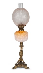 An oil lamp with floral peach glass font, acid etched floral shade, single black button burner and unusual cast metal Chinese acrobat base, 19th century and later, 70cm high.