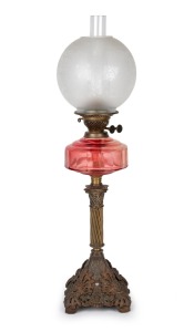 An oil lamp with faceted ruby glass shade, black button double burner and acid etched glass shade, 19th century and later, 76cm high.
