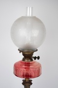An oil lamp with faceted ruby glass shade, black button double burner and acid etched glass shade, 19th century and later, 76cm high. - 2
