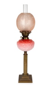 An antique oil lamp with pink glass font, white button double burner, pink acid etched shade and brass column base, 19th/20th century, 71cm high.