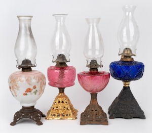 Four antique oil lamps with coloured glass fonts and cast metal bases, 19th/20th century, ​​​​​​​the largest 53cm high.